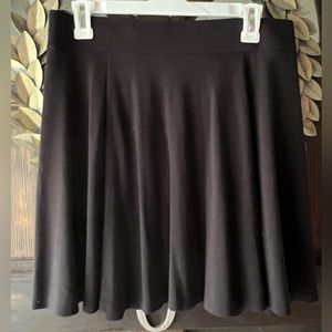 Barely worn- mini skirt with a flare. Zips in the back. Material is giving